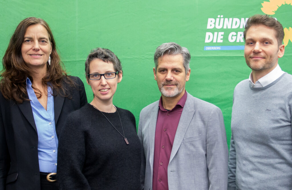Vier Personen vor grünem Hintergrund