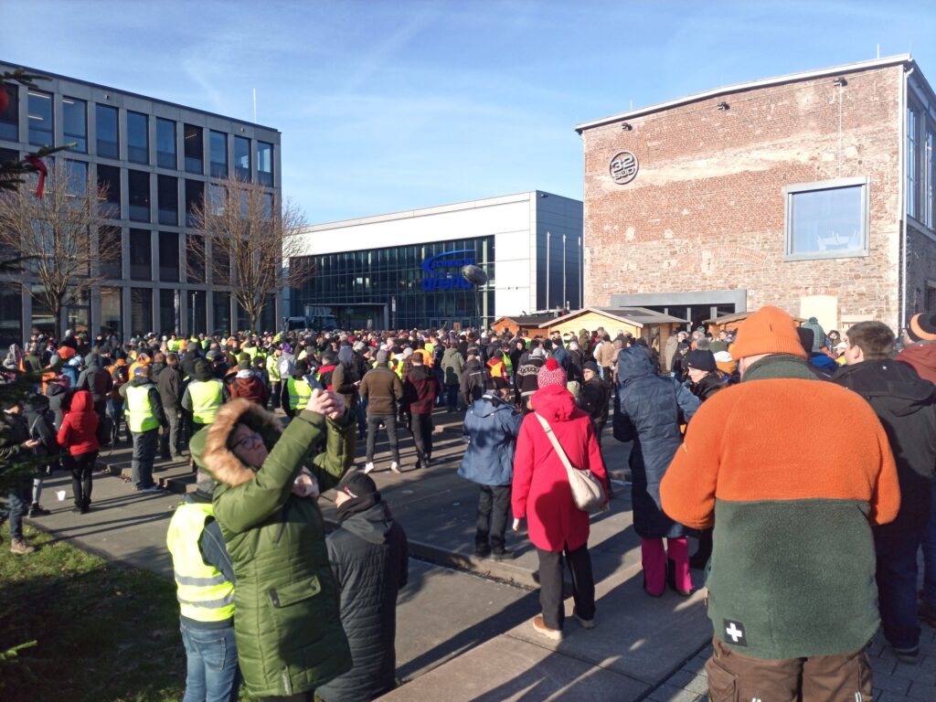 Eine Menschenmenge auf einem Platz, im Hintergrund Gebäude